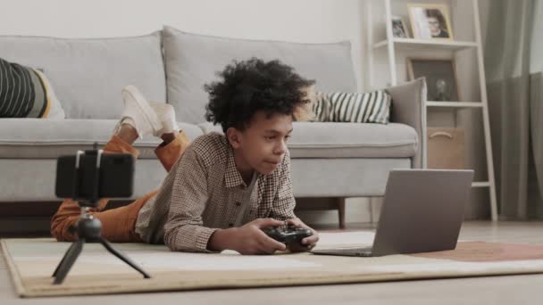 Ampla Foto Streamer Africano Adolescente Deitado Estômago Chão Jogando Jogo — Vídeo de Stock