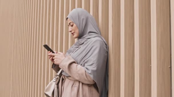 Panning Side View Slow Shot Współczesnej Arabki Hidżabie Sms Smartfonie — Wideo stockowe