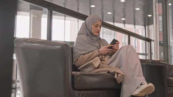 Pan Slow Scatto Donna Araba Contemporanea Hijab Scorrimento Smartphone Mentre — Video Stock