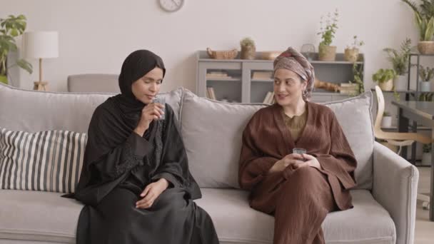 Tiro Médio Duas Jovens Mulheres Muçulmanas Atraentes Hijabs Conversando Bebendo — Vídeo de Stock