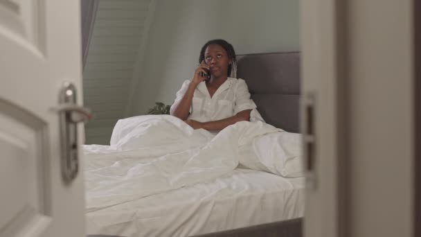 Beyaz Pijamalı Rahat Bir Yatak Odasında Arkadaşlarıyla Telefonda Konuşan Afro — Stok video