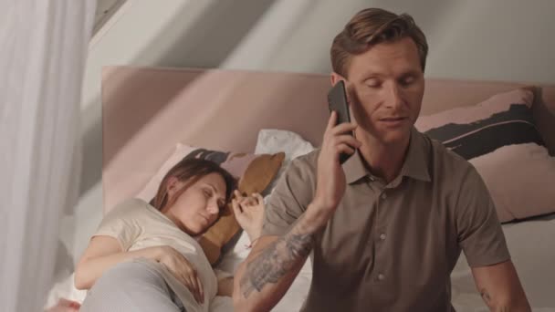 Beyaz Tenli Genç Adam Evde Yatakta Oturuyor Cep Telefonuyla Sessizce — Stok video