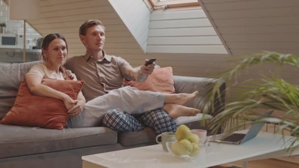 Tracking Left Happy Heterosexual Caucasian Couple Sitting Couch Home Watching — Stock Video