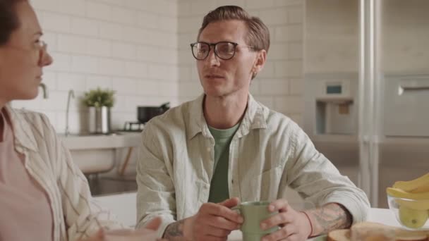 Медленное Движение Белокожего Мужчины Сидящего Кухонным Столом Разговаривающего Женой Которая — стоковое видео