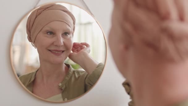 戴头巾 面带微笑的中年妇女的肩头特写 在家中的癌症康复镜像中得到了体现 — 图库视频影像
