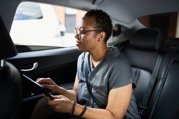 Kobieta korzystająca z tabletu w samochodzie — Zdjęcie stockowe