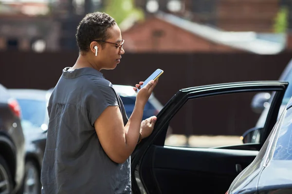 Mulher lendo uma mensagem no parque de estacionamento — Fotografia de Stock