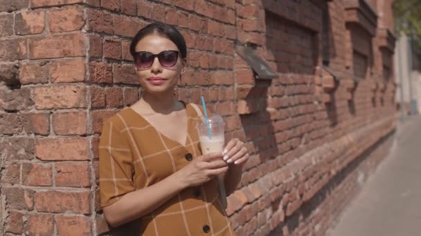 Medium Young Mixed Race Woman Wearing Sunglasses Drinking Iced Coffee — Stock Video