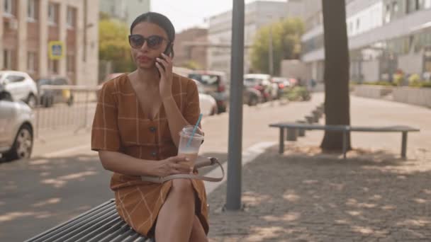 Střední Moderní Míšenka Letních Šatech Slunečních Brýlích Mluví Mobilu Pije — Stock video