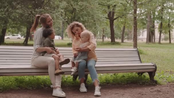 Young Caucasian Women Toddler Kids Sitting Bench Park Warm Sunny — Stok video