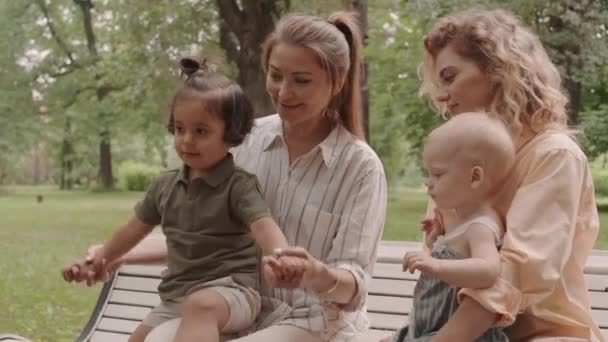 Mittlere Aufnahme Von Zwei Jungen Fröhlichen Frauen Mit Niedlichen Kleinkindern — Stockvideo