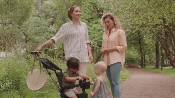 Zwei Junge Frauen Mit Niedlichen Kleinkindern Stehen Draußen Auf Dem — Stockvideo