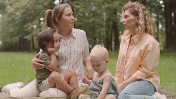 Mittlere Aufnahme Von Zwei Jungen Frauen Mit Kleinkindern Die Auf — Stockvideo