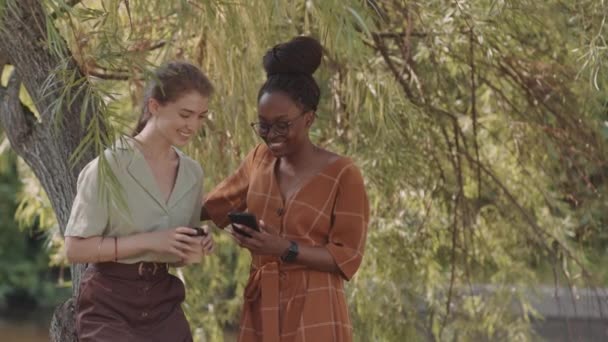 Medium African Woman Holding Smartphone Showing Screen Caucasian Friend Who — Αρχείο Βίντεο