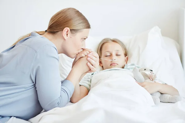 Moeder verzorging voor meisje in het ziekenhuis — Stockfoto