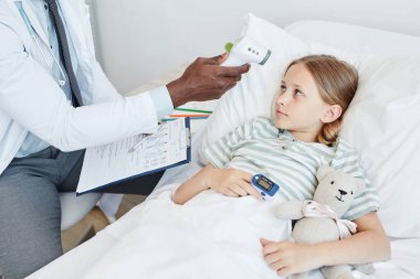 Doctor Checking Temperature of Child in Hospital