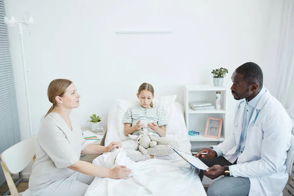 Афроамериканський лікар, який розмовляє з батьками в лікарні — стокове фото