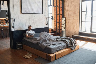Man Relaxing in Bed Wide Angle