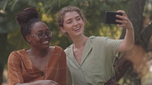 Cintura Dos Amigas Africanas Caucásicas Sonriendo Tomando Selfies Usando Smartphone — Vídeos de Stock