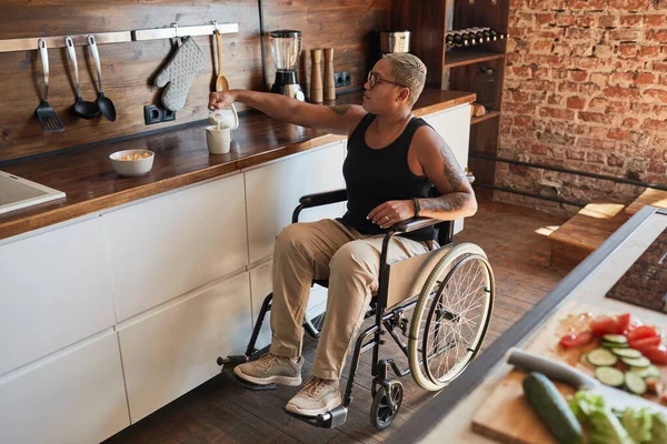 Donna moderna in sedia a rotelle a casa — Foto Stock
