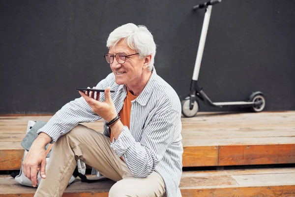 Hombre mayor activo usando Smartphone en la ciudad —  Fotos de Stock