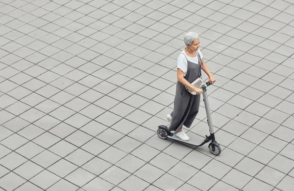 Contemporâneo Senior mulher equitação Scooter — Fotografia de Stock