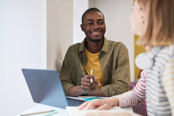 Étudiant souriant travaillant avec un ami — Photo