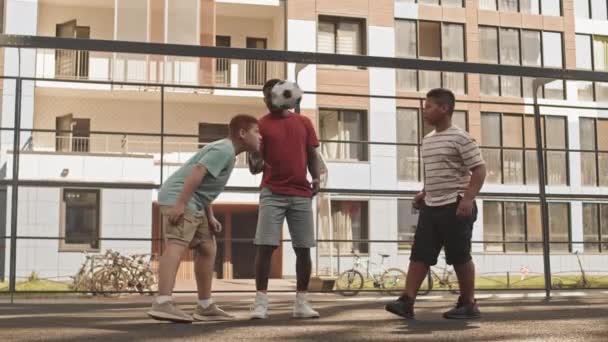 全片拍摄的快乐的非裔美国人和他的两个年轻的儿子在玩足球 他们在运动场外手舞足蹈 — 图库视频影像