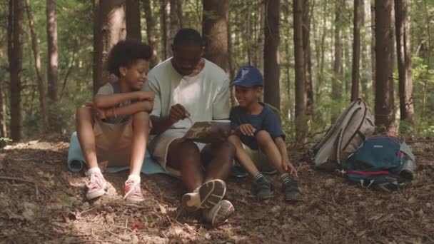 슬로우모는 귀여운 아프리카계 과그들의 아버지가 캠핑을 지도를 어디로 결정하는 장면을 — 비디오