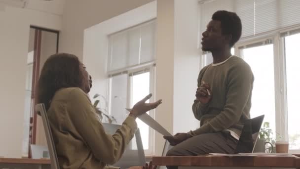 中镜头的年轻非洲裔美国男女在现代办公室里热烈讨论商业文件 — 图库视频影像