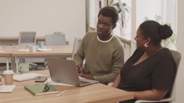 在现代办公室里 两对非洲裔美国人的商业伙伴或同事坐在一起 坐在一张长长的桌子前 一边聊天 一边在笔记本电脑上工作 — 图库视频影像