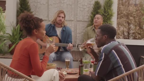 Dört Neşeli Çoklu Etnik Arkadaşın Kokteyllerin Keyfini Çıkarırken Canlı Müzik — Stok video