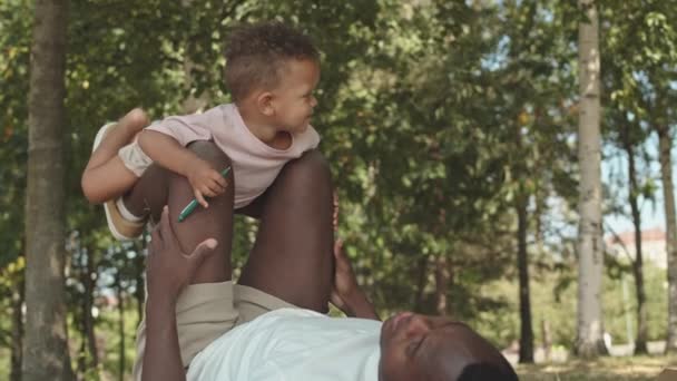 Yavaş Çekimde Neşeli Bir Afro Amerikalı Çocuk Kucağında Bacağıyla Güneşli — Stok video