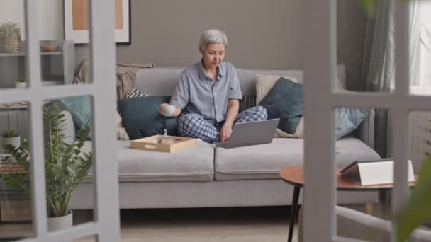 Spårning Höger Senior Asiatisk Kvinna Bär Loungewear Sitter Med Korsade — Stockvideo