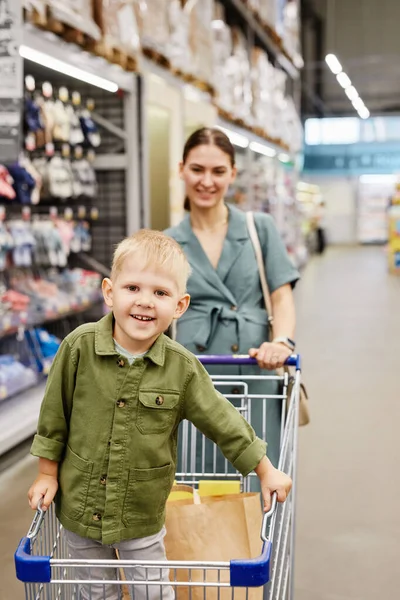 Empujando carrito de compras con hijo — Foto de Stock