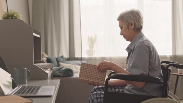 Engelli Yaşlı Asyalı Bir Kadının Kitaptan Bir Kitap Seçip Eve — Stok video