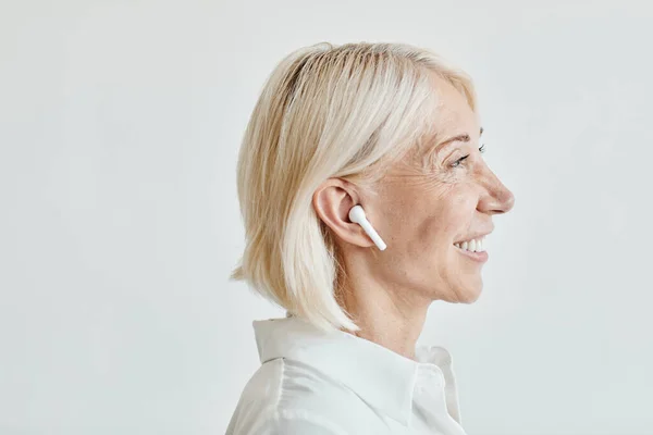 Посмішка зрілої жінки з навушниками — стокове фото