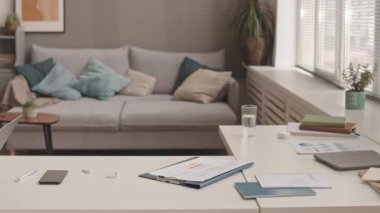 Üst düzey Asyalı yöneticinin solunda oturmuş bilgisayarla video görüşmesi yapıyor, uzaktan kumandayla çalışıyor.