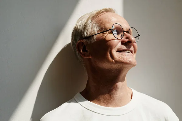 Hombre mayor sonriente a la luz del sol —  Fotos de Stock