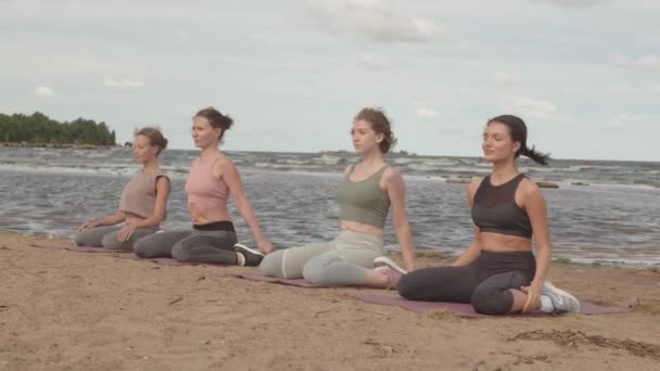 Langzame Opname Van Vier Jonge Vrouwen Die Samen Strandyoga Beoefenen — Stockvideo