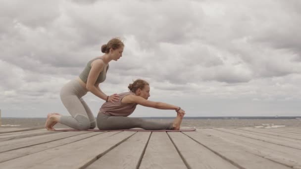 Langzaam Schot Van Vrouwelijke Yoga Coach Helpend Jonge Vrouw Tijdens — Stockvideo