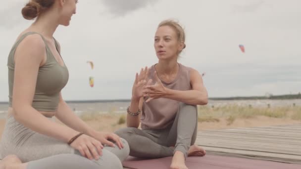 Lento Disparo Mujer Joven Hablando Con Entrenador Yoga Femenino Sentado — Vídeo de stock