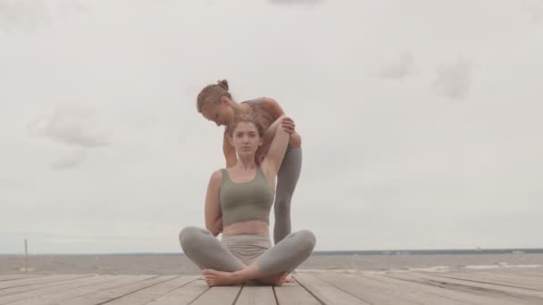 Apuñalada Entrenadora Yoga Femenina Ayudando Joven Agarrarse Las Manos Antes — Vídeo de stock