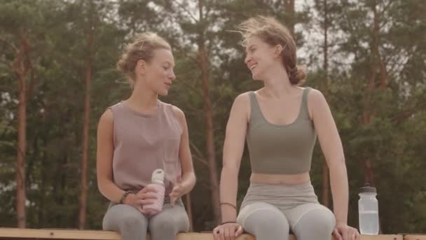 Lento Disparo Dos Mujeres Jóvenes Ropa Deportiva Descansando Parque Después — Vídeo de stock