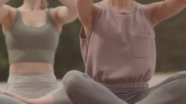 Rüzgarlı bir günde meditasyon sırasında dua eden iki kadın elinin ortası.