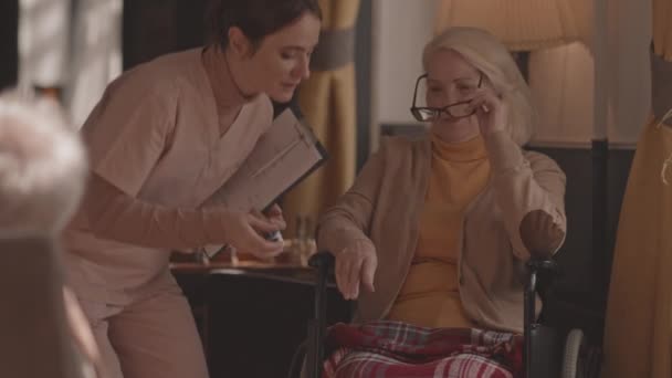 Slowmo Shot Young Nurse Clipboard Taking Care Old Lady Wheelchair — Stock Video