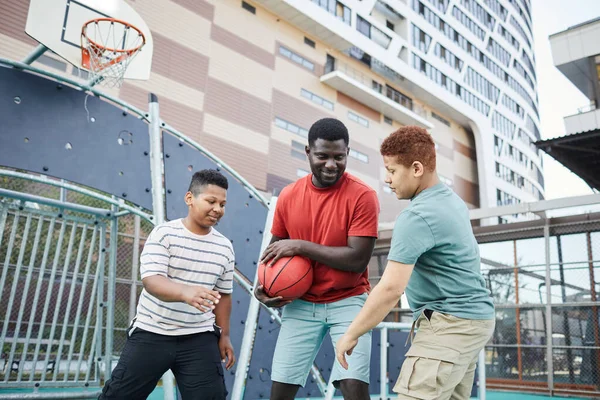 Jugar al baloncesto en el campo de deportes de la ciudad — Foto de Stock