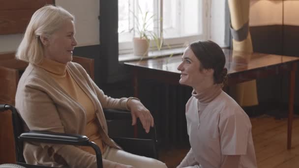 Slowmo Tiro Jovem Enfermeira Carinhosa Sorridente Mulher Idosa Cadeira Rodas — Vídeo de Stock