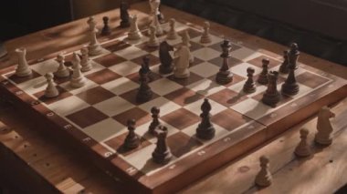 Yukarıdan yakından çekilen ahşap satranç tahtası ve masa taşları yok.
