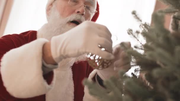Kantel Omhoog Van Kerstman Opknoping Decoratieve Gouden Bal Aan Kerstboom — Stockvideo